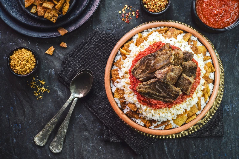 El fettah oriental egipcio Fettah oriental egipcio con arroz blanco y pan crujiente cubierto con salsa roja de ajo sazonada, ajo frito crujiente