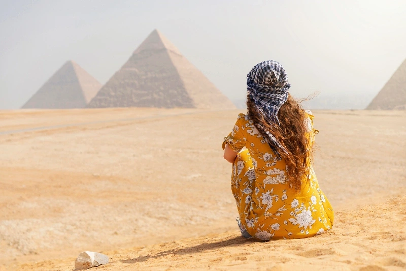 una donna davanti alle piramidi, viaggiare sicuri egitto