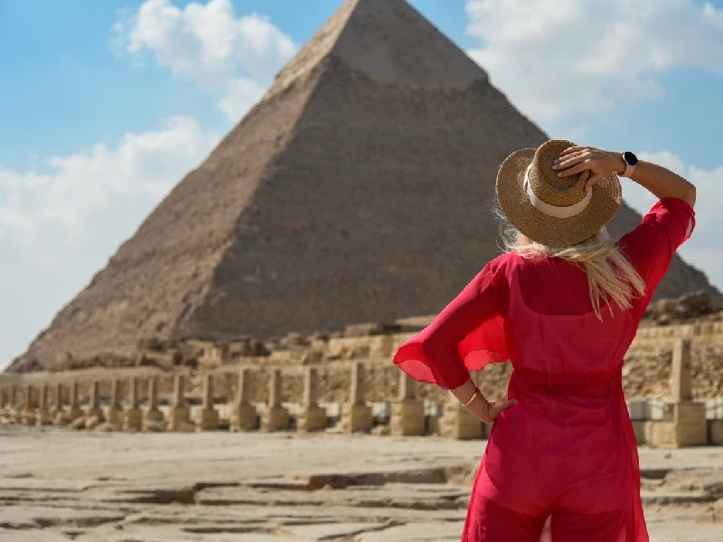 una donna davanti a una piramide
