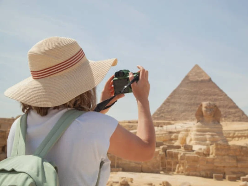 una donna fotografa le piramidi e la sfinge