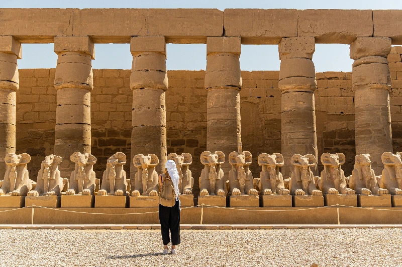 Turista paseando por el templo de Karnak en Luxor, entre la avenida de esfinges en Tebas