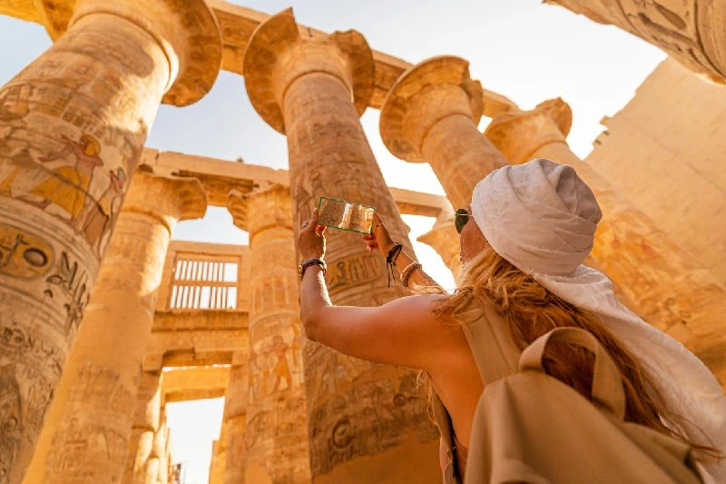 una ragazza scatta foto alle colonne dei templi di Luxor,  luxor o il cairo