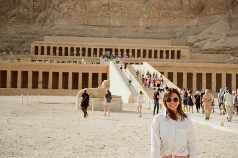 viaggiatrice sorridente davanti al tempio di hatshepsut, viaggio in egitto cosa sapere