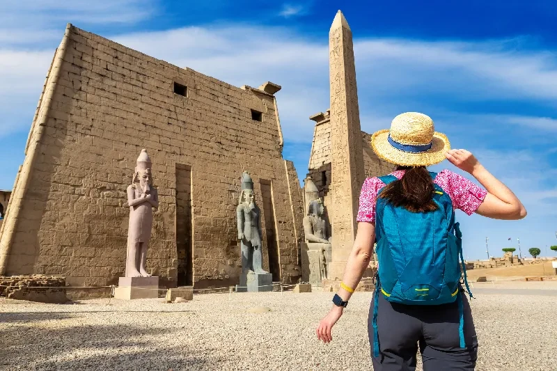 viaggiatrice con cappello di paglia davanti al pilone e all’obelisco del tempio di luxor, viaggio in egitto cosa sapere