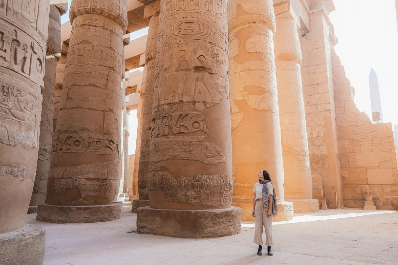 Mujer caminando en el antiguo templo egipcio de Luxor