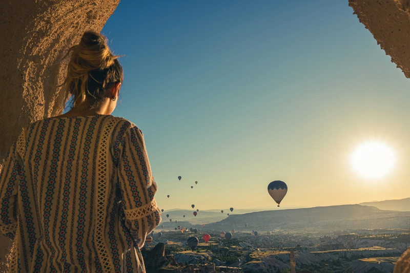 Turista observando globos aerostáticos en Capadocia Turista observando globos aerostáticos en Capadocia