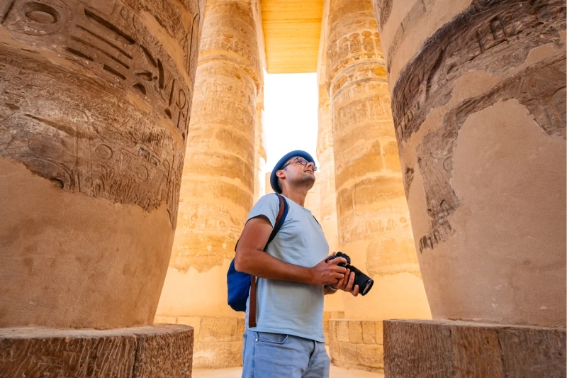 Templo de Karnak Fotógrafo tomando fotografías con cámara del complejo del templo de Karnak en Luxor, Egipto.