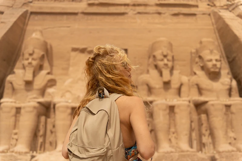 Templo del faraón Ramsés II. Egipto, Asuán, Abu Simbel Mujer de vacaciones frente al increíble Templo de Abu Simbel, reconstruido en la montaña del sur de Egipto, en Nubia, junto al lago Nasser. Templo del faraón Ramsés II. Egipto, Asuán, Abu Simbel.