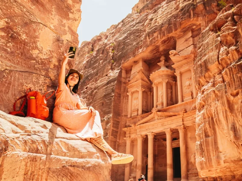 Viaggiatrice scatta un selfie davanti al Tesoro di Petra, Giordania a Natale