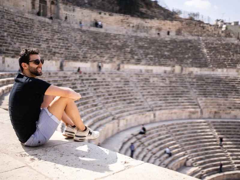 Viaggiatore seduto sulle gradinate del Teatro Romano, Giordania a Natale