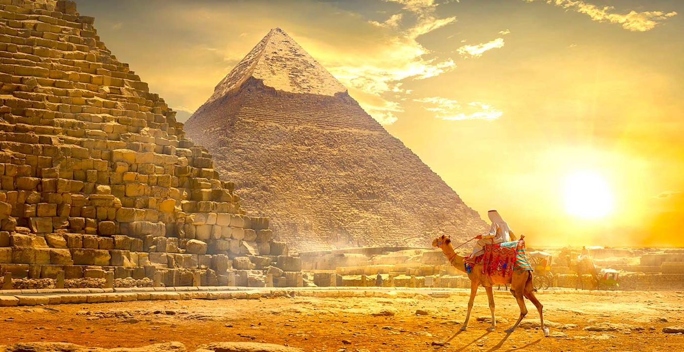 Un uomo cavalla un cammello davanti alla piramide