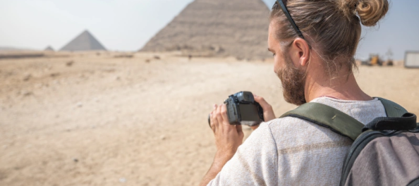 Uomo scatta una foto alle piramidi, viaggi pasqua egitto