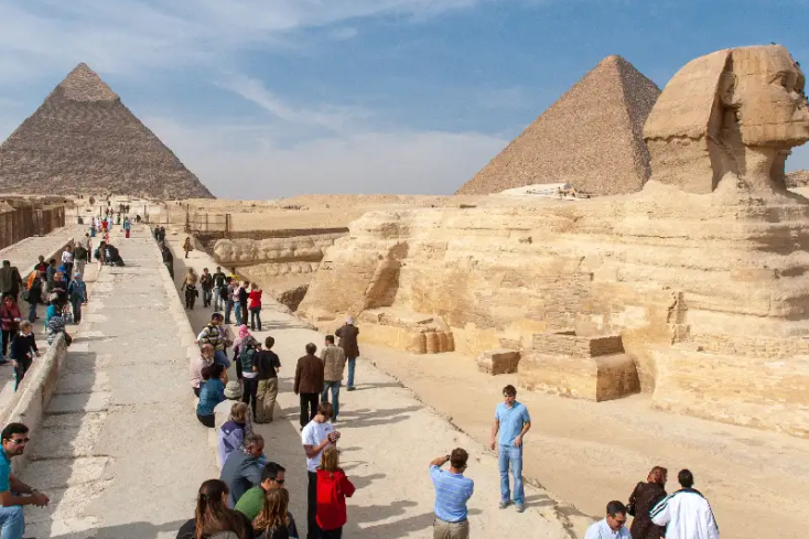 un gruppo di turisti visitano le piramidi, come organizzare un viaggio in Egitto