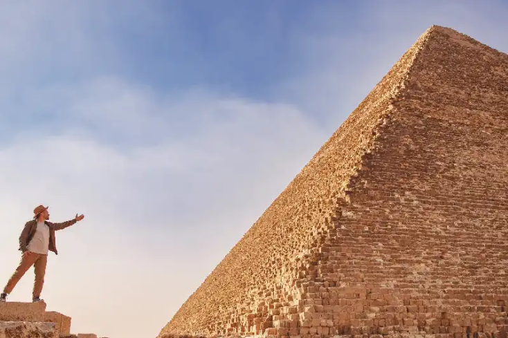 un uomo davanti alla grande piramide, dove andare in egitto a dicembre