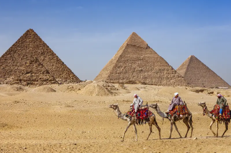 tre uomini su cammelli davanti alle piramidi, cosa vedere al cairo in 4 giorni