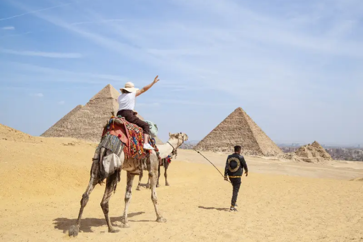 una donna cavalca un cammello a giza, Egitto posti da visitare