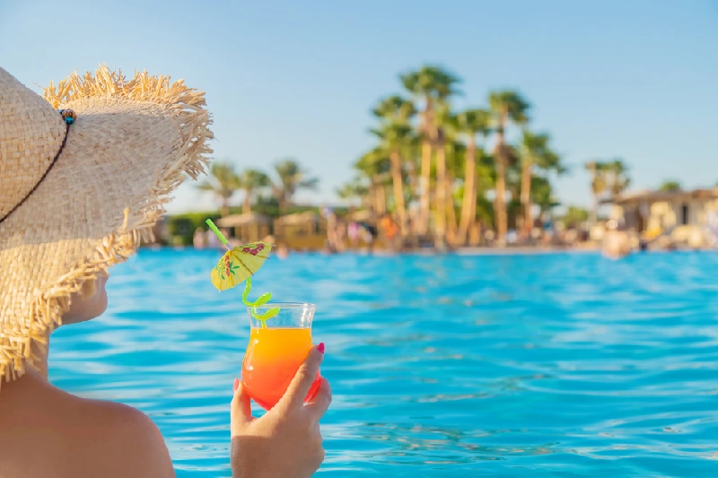 Escursione in Sottomarino Sindbad a Hurghada, Una donna che tiene il succo tra le mani e si siede sul mare