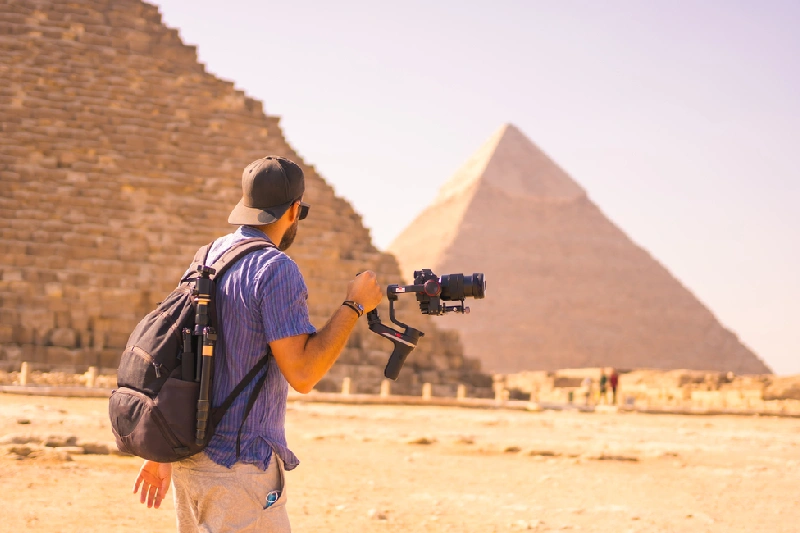 Tour il Cairo in 2 giorni da Sharm,  un uomo con una camera a mano davanti alle piramidi