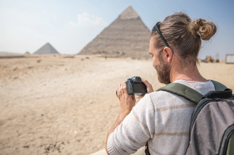 Uomo scatta una foto alle piramidi, viaggi pasqua egitto