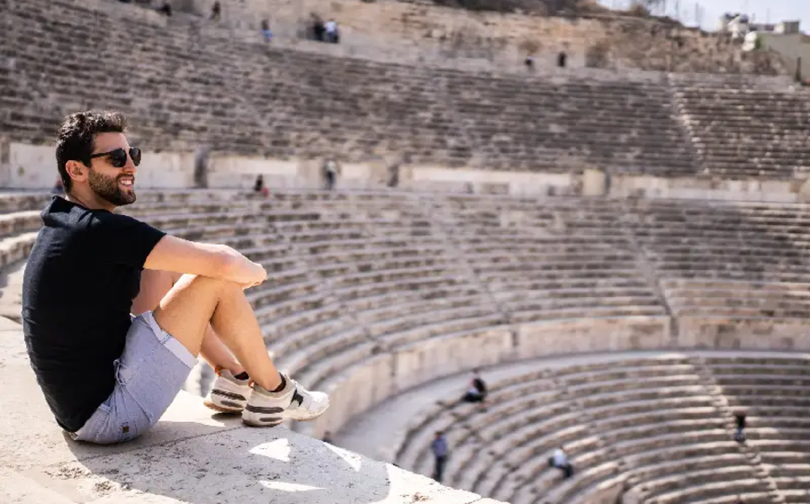 un uomo al teatro romano a giordania, situazione in giordania