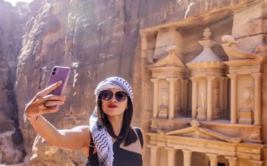 una donna fa una foto a petra, situazione in giordania
