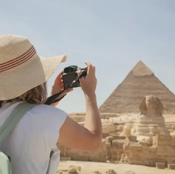 una donna scatta una foto per la piramide , dove andare in egitto a dicembre