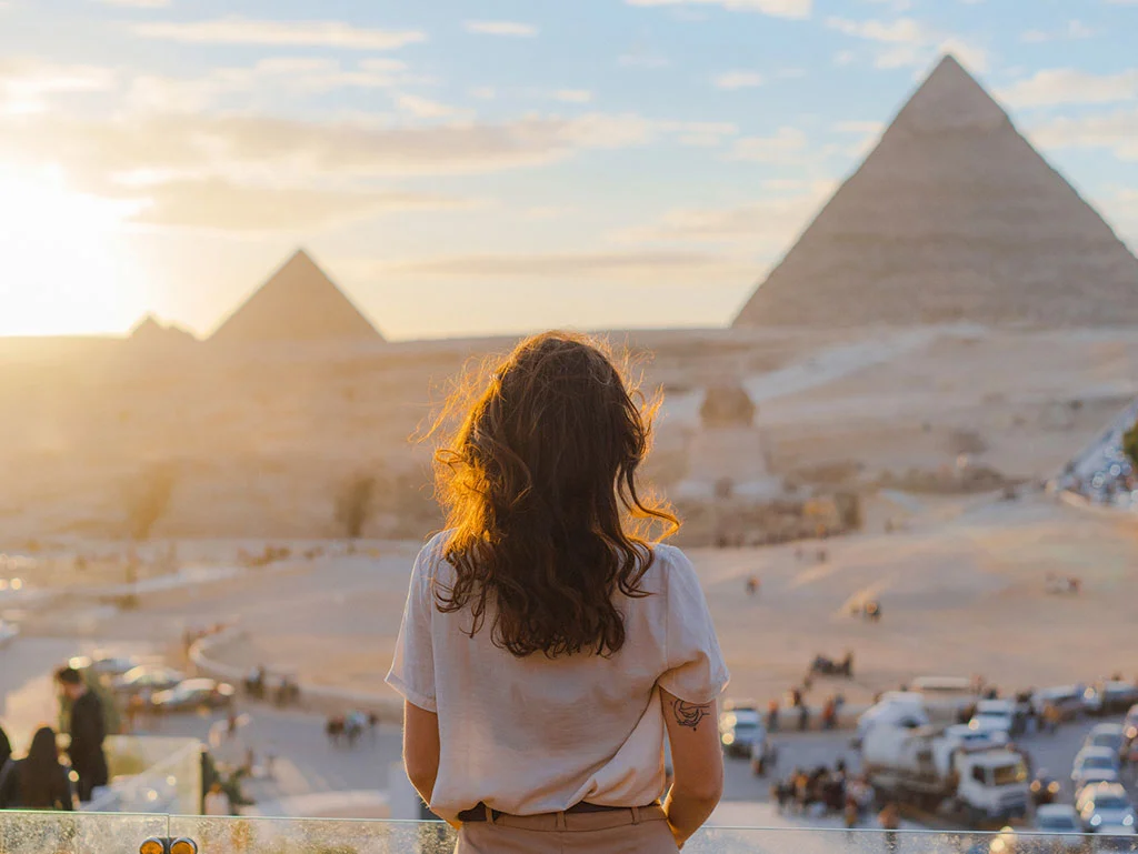 a girl standing infront of of pyramids in Giza