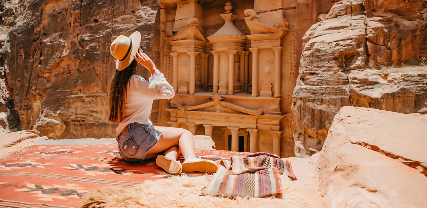 a girl in white shirt in front of petra