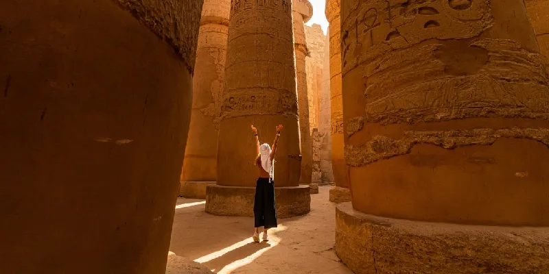 una mujer turista en la sala hipóstila del Templo de Karnak