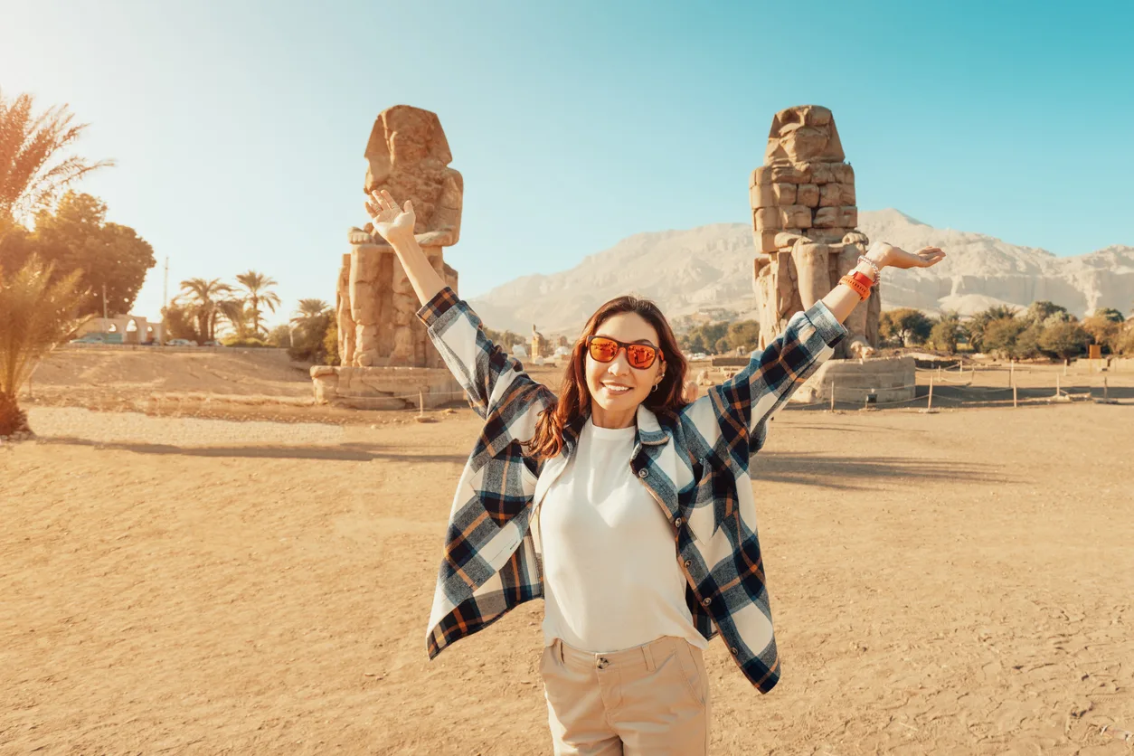 a female tourist at the memnon colosuss in Luxor, Cairo Luxor tour