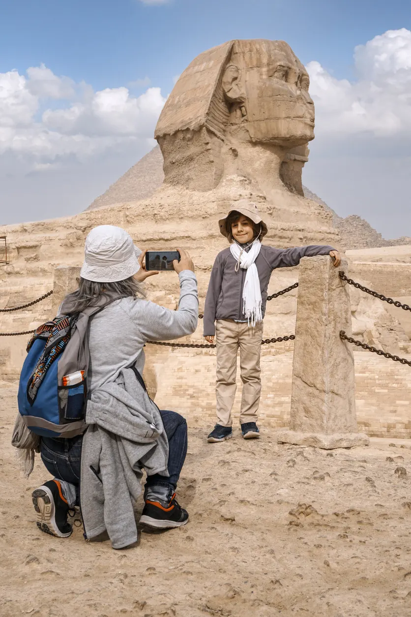 Tourist taking a picture of her son in front of the great sphinx of giza, Port Said to Cairo