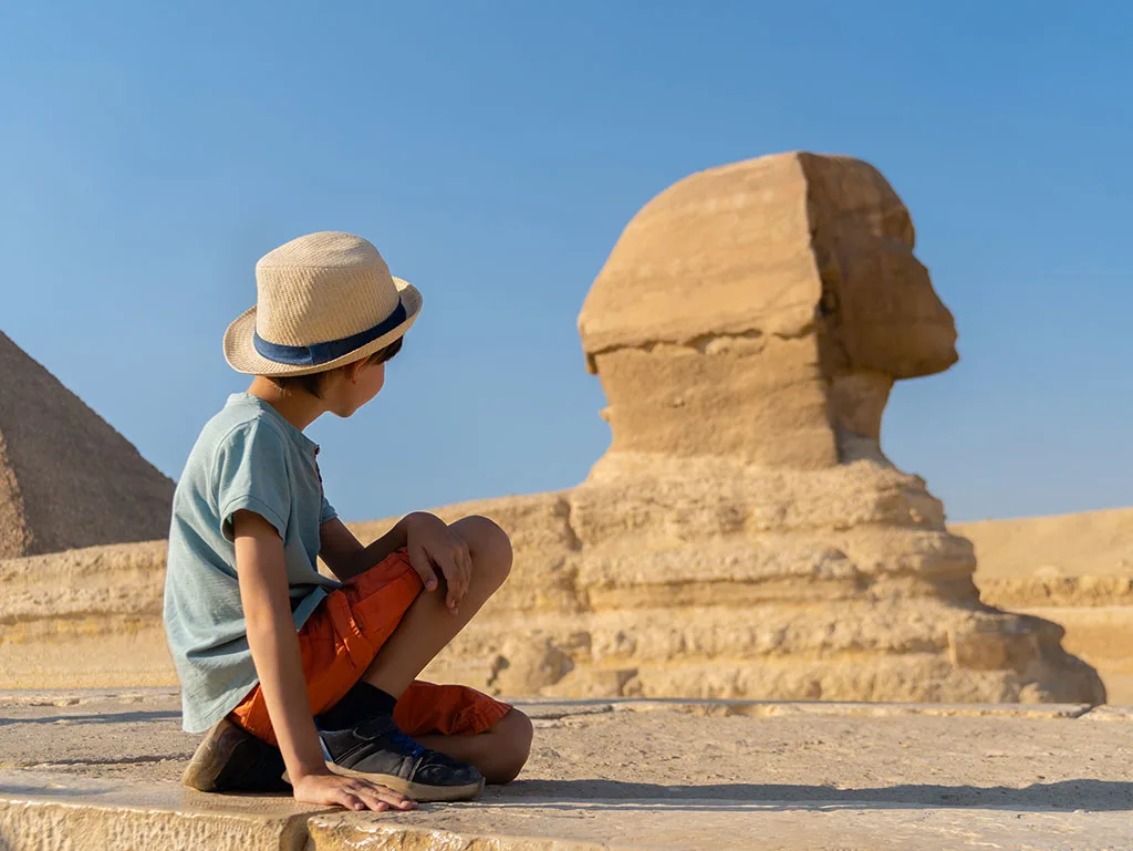 a kid taing picture by Sphinx in Giza, Cairo and Luxor Tour by Sleeper Train