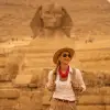 Mujer de pie frente a las pirámides de Giza y la Esfinge. Giza, Egipto.