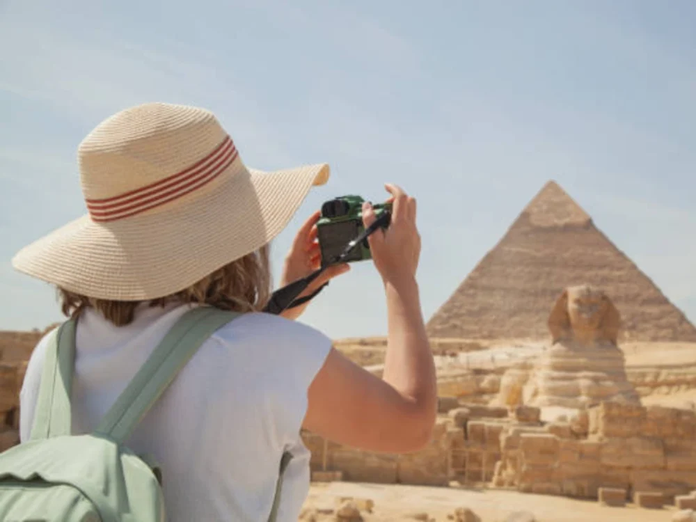 una donna fotografa le piramidi e la sfinge