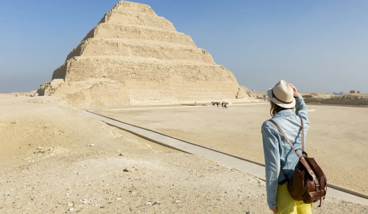 a girl stands in front of the pyramids of djoser, Tour Guide to Egypt