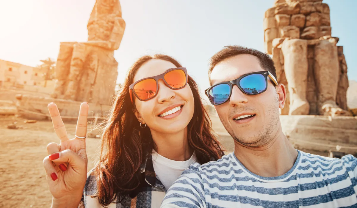 Couple takes selfie in front of Colossi of Memnon, Tour Guide to Egypt