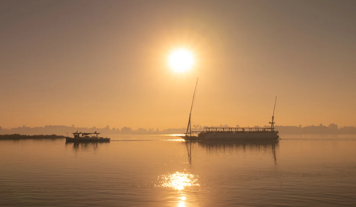 Silhouette of a traditional egyptian dahabiya boat cruising on the Nile river at sunset, Egypt
