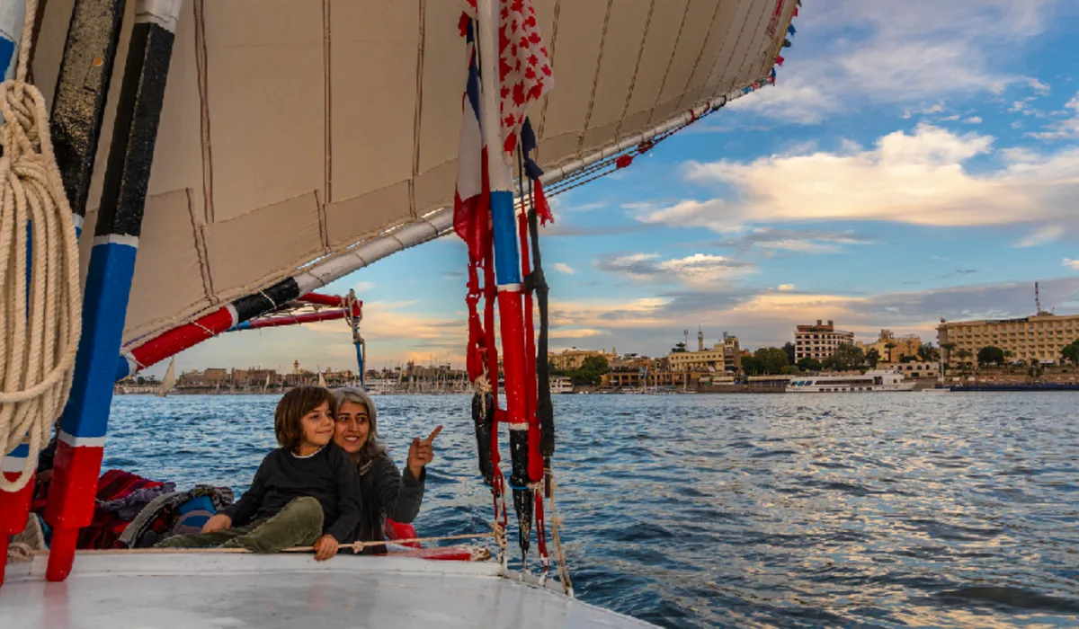 Mother and son travel on a felucca boat in Luxor