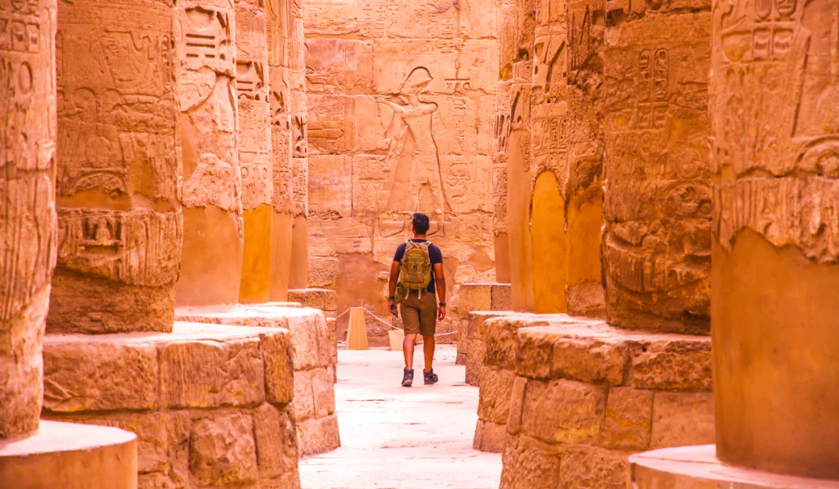 a man walking between columns in karnak temple, Karnak Temple