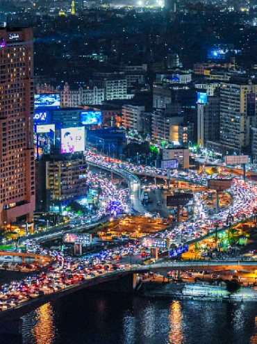 Vista nocturna de El Cairo que muestra el río Nilo, el Hotel Hilton, el puente Qasr El Nil y los atascos de tráfico.