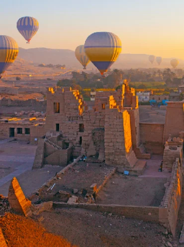 Globo aerostático sobrevolando el templo mortuorio de Ramsés III en Medinet Habu, en la necrópolis tebana del Valle de los Reyes, Luxor, Egipto.