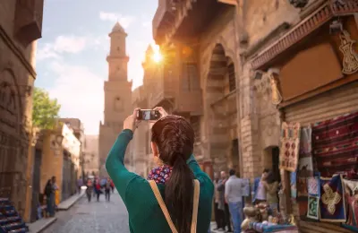 Turista fotografa una strada storica del Cairo islamico