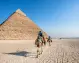 Foto della Piramide di Chefren e di turisti a passeggio con dei cammelli durante il tour Cairo e Luxor