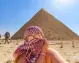 Donna con Kefiah e occhiali davanti alla Piramide di Chefren durante il tour di 10 giorni in Egitto tra Cairo e Nilo