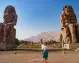 Turista in una foto tra i colossi di Memnon visitabile durante il tour con crociera sul Nilo
