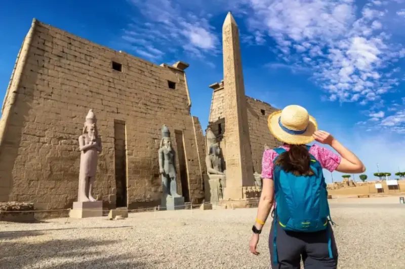 Turista che guarda l'obelisco davanti al tempio di Luxor