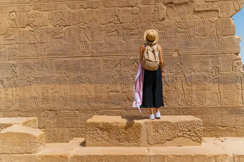 Viaggiatrice che osserva i geroglifici sul fianco del tempio Ipetro
