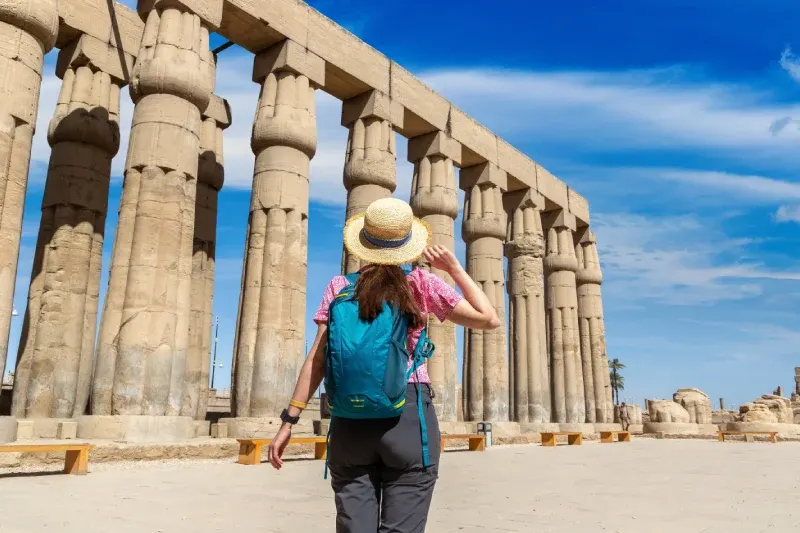 Viaggiatrice di spalle davanti alle rovine dell'Antico Egitto
