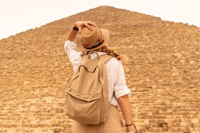 Donna che si tiene il cappello mentre ammira le Piramidi d'Egitto