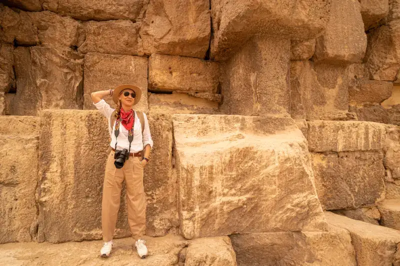 Foto di una turista con gli enormi massi che costituiscono la Piramide